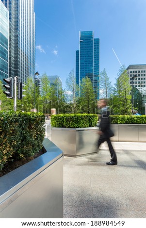 Business executive walking outside of modern office buildings