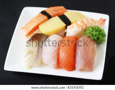 sushi of raw fish, grilled fish, egg, shrimp and crab stick on white plate