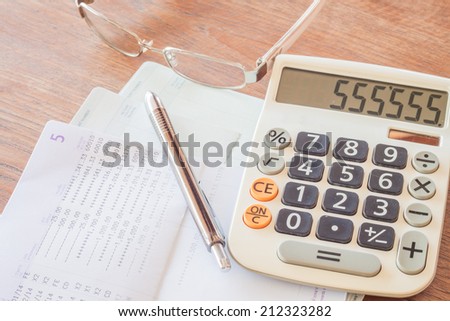 Calculator, pen and eyeglasses on bank account passbook, stock photo