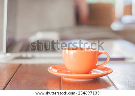 Mini orange coffee cup on work station, stock photo