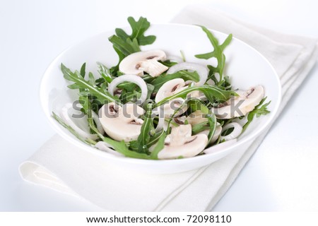 Fresh salad with rucola, mushrooms and onion in bowl