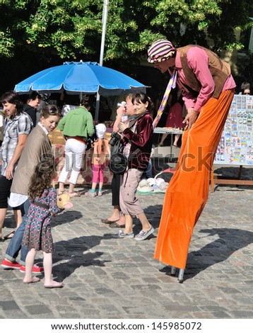 KIEV, UKRAINE Ã¢Â?Â? CIRCA JUNE 2013: Unknown man on stilts speaks with unknown girl on the open street festival of music and art on June 2013 in Kiev, Ukraine.
