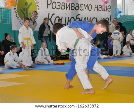 KOTSYUBYNSKE, UKRAINE - SEPTEMBER 3:  Unknown boys make the duel fight on the youth judo competition on September 3, 2013 in Kotsyubynske, Ukraine.