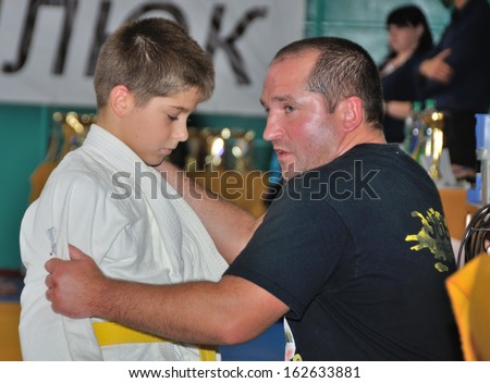 KOTSYUBYNSKE, UKRAINE - SEPTEMBER 3: The unknown coach gives an advice to unknown boy on the youth judo competition on September 3, 2013 in Kotsyubynske, Ukraine.