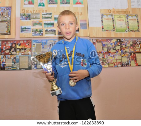 KOTSYUBYNSKE, UKRAINE - SEPTEMBER 3: Unknown boy takes the reward on the youth judo competition on September 3, 2013 in Kotsyubynske, Ukraine.