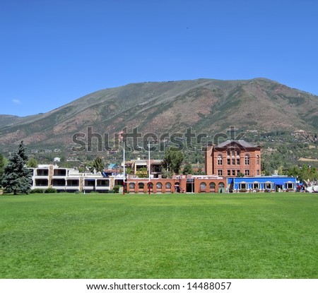 Field and Buildings in Aspen, Colorado with mountain in background.