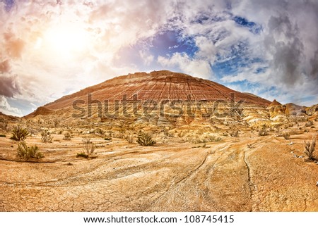 Aktau mountains scenery with drought earth at dramatic sunset sky in national park Altyn Emel in Kazakhstan, Central Asia