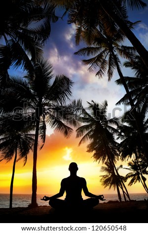 Yoga meditation silhouette by man at palms, ocean and sunset sky background in India