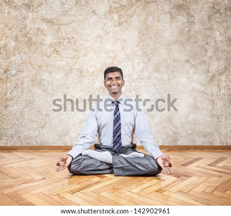 Happy Indian businessman doing meditation in the office