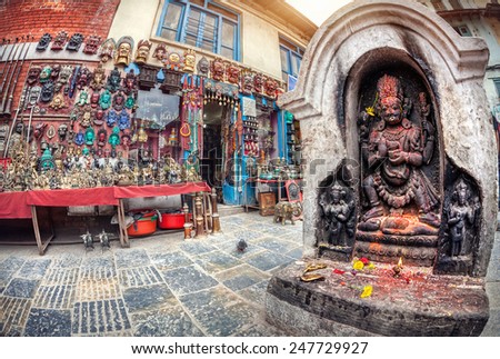 Hindu statue near the shop selling masks and souvenirs on the square near Swayambhunath stupa in Kathmandu valley, Nepal
