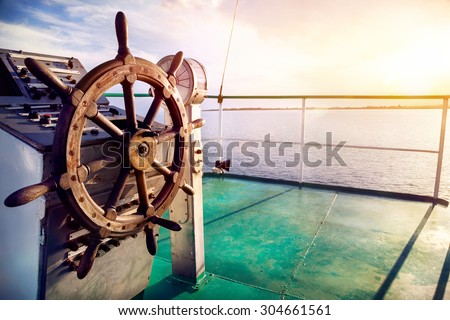 Wooden wheel on the ship at sunset on Issyk Kul lake