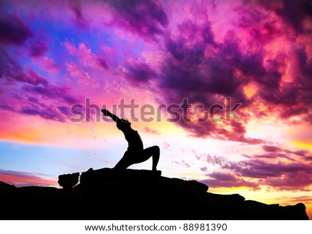 Yoga virabhadrasana I warrior pose by man silhouette with purple dramatic sunset sky background. Free space for text and can be used as template for web-site