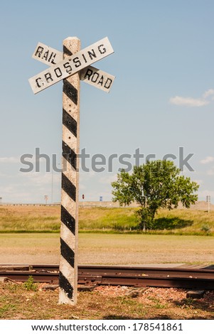 Vintage railroad crossing sign and post at the tracks