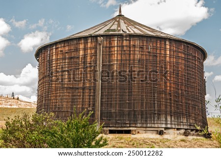 Water tank constructed of clear redwood lumber with a conical roof system.
