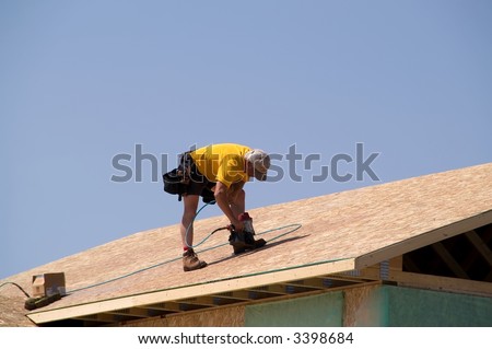 Construction Worker Using Nail Gun To Nail Osb Sheeting On Roof Of A ...