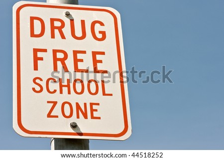 Sign for drug free school zone with red letters on white  background