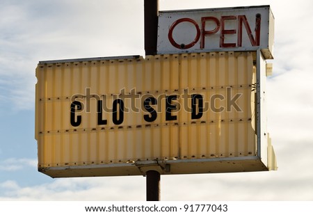 Open sign has lost part of it\'s neon tubing and the letters have been painted red.  Closed sign is for the same business sending very mixed messages to those passing by.