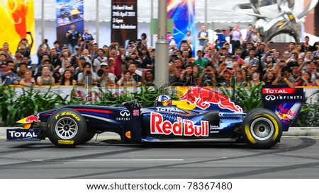 SINGAPORE - APRIL 24: David Coulthard, performs donuts in Redbull Racing Car on the streets of Orchard Road on April 24, 2011 in Singapore.