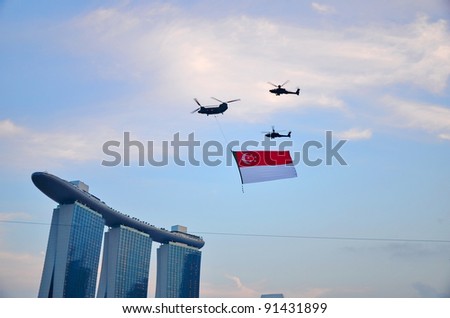 SINGAPORE - AUGUST 9: Chinook helicopter flying Singapore national flag at National Day Parade Singapore 2011 on August 9, 2011 in Singapore.