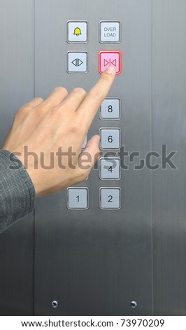 businessman hand press close door button in elevator