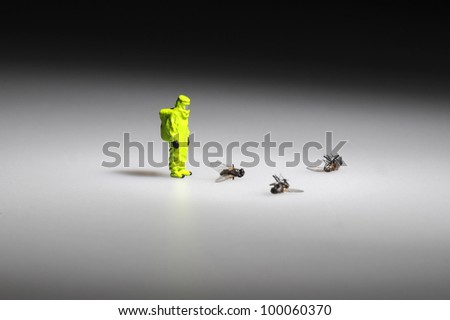 tiny figure of firefighter in hazmat,suit standing next to dead flies