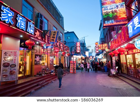 BEIJING, CHINA - MARCH 27:  Chinese people walks next to restaurants on one of the parallel street to famous Qianmen Dajie pedestrian commercial street on March 27, 2013 in Beijing