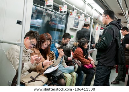 SHANGHAI, CHINA - MARCH 21: Chinese people sits with mobile phones in Shanghai metro train on March 21, 2013 in Shanghai