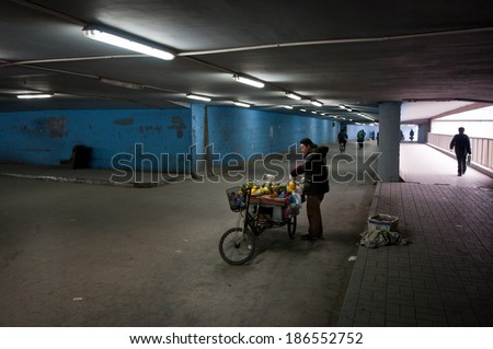 BEIJING, CHINA - MARCH 29: Man sells carved pineapples in underground passage on March 29, 2013 in Beijing