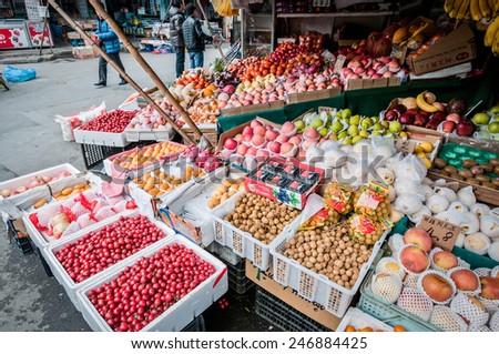 SHANGHAI, CHINA - MARCH 22: People passing next to greengrocery with vegetables and fruits at food market on March 22, 2013 in Old City of Shanghai (Nanshi)