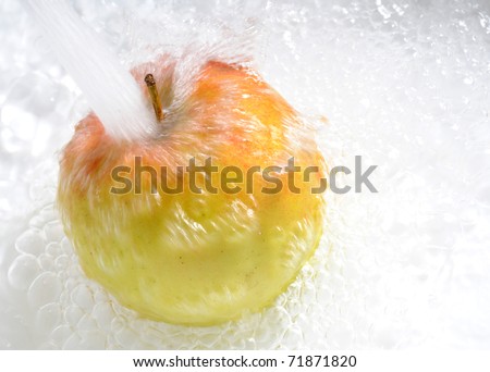 running tap water pouring on single apple