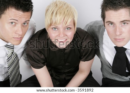 Businesswoman and two businessman looking at you