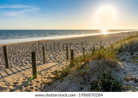 Similar – Image, Stock Photo Wide sandy Faro beach with dunes and walkways by the sunset, Algarve, Portugal