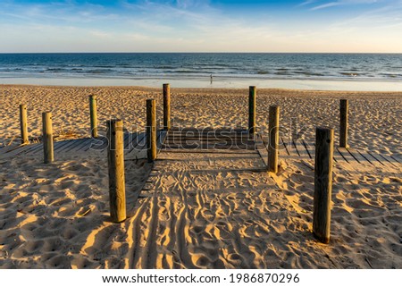 Similar – Image, Stock Photo Wide sandy Faro beach with dunes and walkways by the sunset, Algarve, Portugal