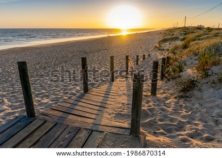 Similar – Image, Stock Photo Wide sandy Faro beach with dunes and walkways by the sunset, Algarve, Portugal