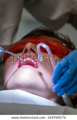 Patient in dentist office - cleaning and repairing teeth