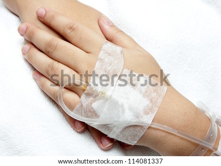 woman hand,Left hand  with saline intravenous (iv) in hospital put on right hand and white cloth