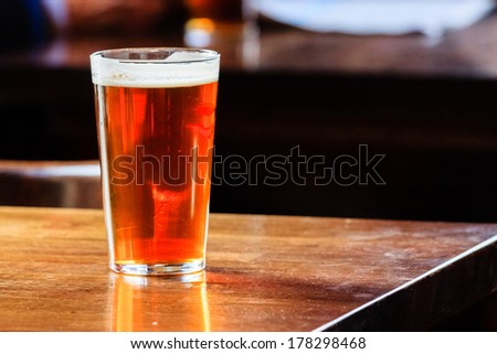 An english ale on a wooden table in a pub in London, UK