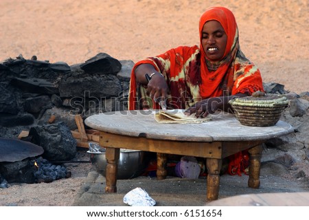 The woman - Bedouin  makes  traditional flat cakes of a flour . Marsa Alam. Egypt