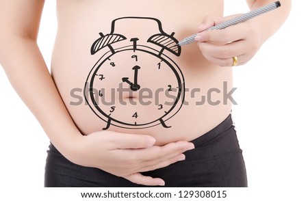 Concept image of pregnant belly with painting clock isolated on the white background.