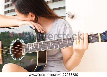 Lady not playing classic acoustic guitar.