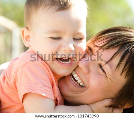 Portrait of a happy mother hugging her son outdoors