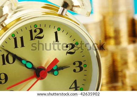 Old-fashioned clock dial on golden coins background, time is money concept