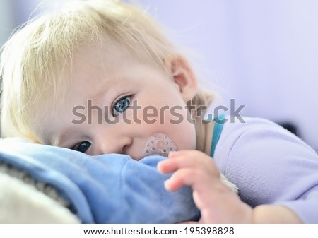 Cute baby with blue eyes hugging a mascot. MANY OTHER PHOTOS FROM THIS SERIES IN MY PORTFOLIO.
