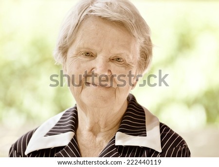 Senior happy woman smiling in garden. Vintage style.