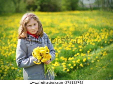Young girl with bouquet of yellow flowers on meadow full of dandelions. MANY OTHER PHOTOS FROM THIS SERIES IN MY PORTFOLIO.