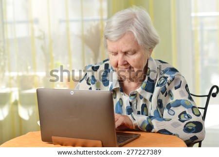 Senior woman with laptop in her room. MANY OTHER PHOTOS FROM THIS SERIES IN MY PORTFOLIO.