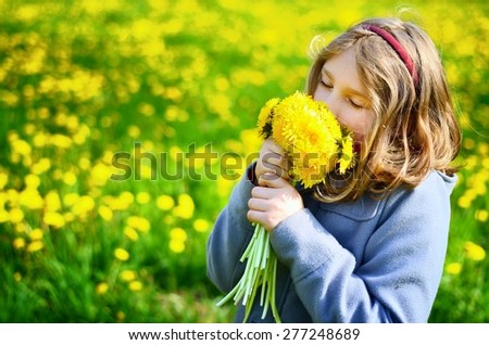 Young girl with bouquet of yellow flowers on meadow full of dandelions. MANY OTHER PHOTOS FROM THIS SERIES IN MY PORTFOLIO.
