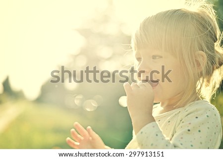 Cute little girl in the sunshine. Back lighting. MANY OTHER PHOTOS FROM THIS SERIES IN MY PORTFOLIO.