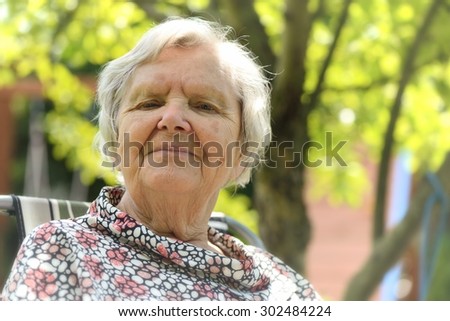 Senior happy woman smiling in garden. MANY OTHER PHOTOS FROM THIS SERIES IN MY PORTFOLIO.