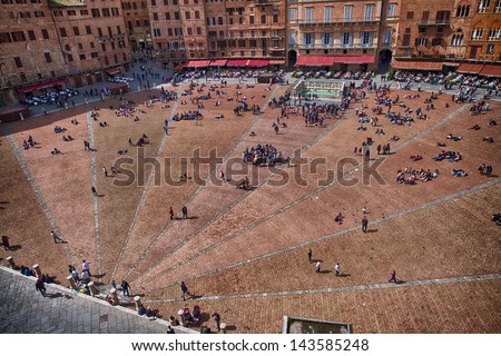 SIENA, ITALY - APR 6: Tourists walk in Piazza del Campo, April 6, 2013 in Siena, Italy. The historic centre of Siena has been declared by UNESCO a World Heritage Site.